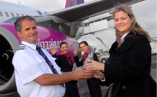 Image: Natasha Manning and Piotr Jabzonski standing in front of a wizzair plane for a commemorative photo