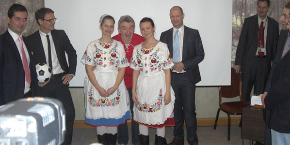 Ryanair CEO Michael O'Leary poses with two women wearing traditional Hungarian dresses.