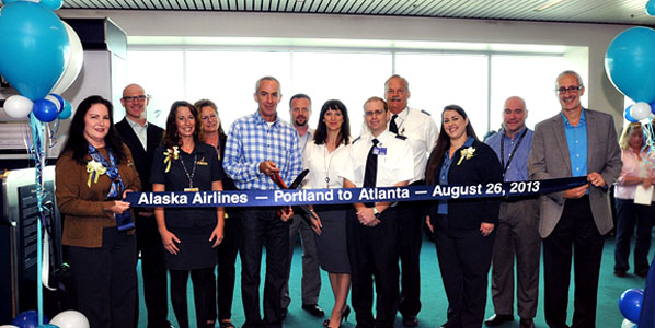 Alaska Airlines staff surround Jeff Spangler, who has achieved the mileage plan level of MVP Gold