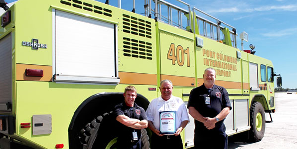 “Rural Metro CMH Fire Chief William Bettac (center with the certificate); flanking him are the drivers who performed the water cannon for the American Airlines 27 August inaugural flight. On the left is Anthony Salamone and on the right is Bill Ballenger.