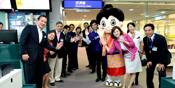 Peach's CEO Mr. Shinichi Inoue (left), Okinawa's promotional character Mahae-chan, local guests from Taiwan, and Peach cabin attendants at the boarding gate in Taipei 