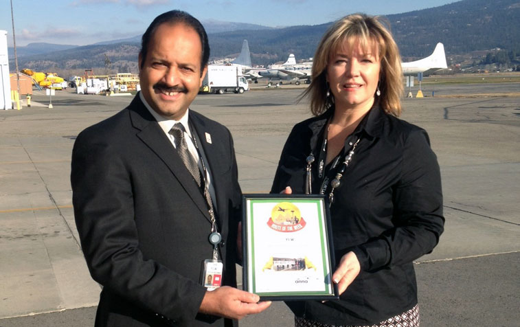 Kelowna Airport Director Sam Samaddar, and Airport Marketing & Media Relations Jenelle Hynes, cradling this week’s anna.aero “Route of the Week” prize.